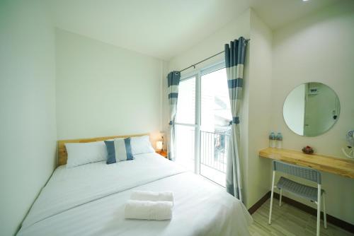 Ban KoNut Home Hostel的一间卧室配有一张带镜子的床和窗户