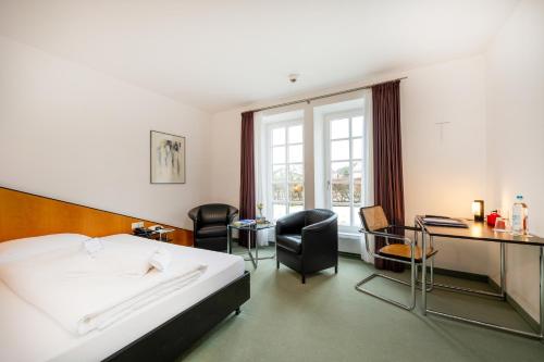 劳特拉赫劳特拉施宫酒店的酒店客房,配有一张床、一张桌子和椅子