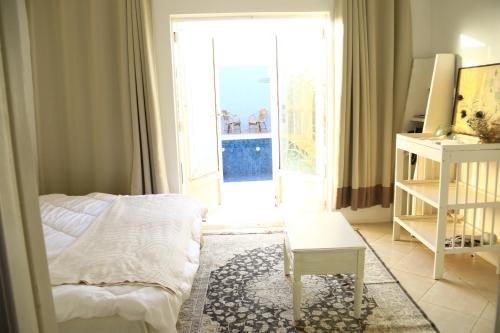 Bir Jedíd Saint-HubertGreenLand的一间卧室配有一张床、一张桌子和一个窗户。