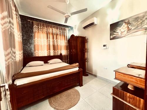 Kiembi SamakiAfrica Mbweni Apartment的一间卧室配有木床和钢琴