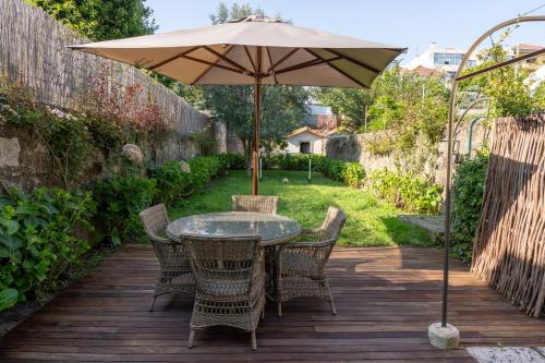 波尔图Porto Premium Villa的木甲板上的桌椅和遮阳伞