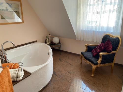 巴特索登-阿伦多夫PARADISE GARDEN的一间带大浴缸和椅子的浴室