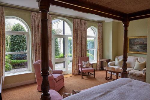 金塞尔佩里维尔楼酒店的一间卧室配有一张床、椅子和窗户。