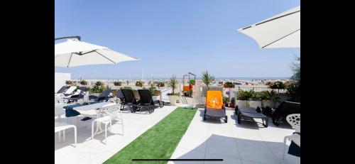 里米尼Riviera Mare Beach Life Hotel的屋顶上带桌椅的天井