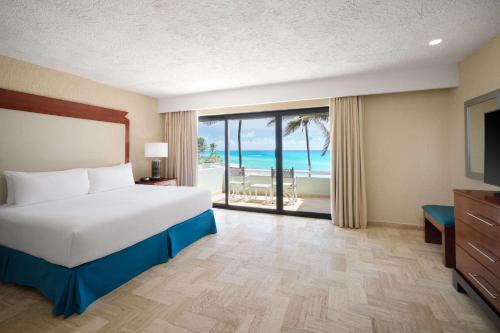 坎昆Wyndham Grand Cancun All Inclusive Resort & Villas的一间卧室配有一张床,享有海景