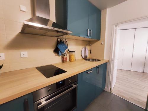 沙朗通勒蓬Cosy Appartement 4P proche 12eme/Vincennes的厨房配有蓝色橱柜和木制台面
