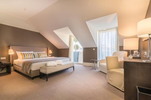 菲盖拉-达福什环球精品酒店的一间卧室配有一张特大号床和一把椅子
