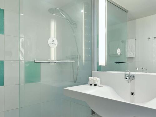 塞尔吉B&B HOTEL Cergy Port 4 étoiles的白色的浴室设有水槽和淋浴。