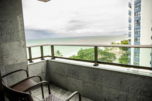 累西腓Nobile Residences Maria Frazão的一个带椅子的阳台,享有海滩美景