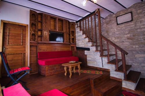 吉诺卡斯特Duplex Apartment KANDILE的一间带红色沙发和楼梯的客厅