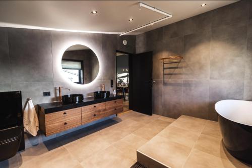 亨宁斯韦尔托比亚百瑞佳公寓式酒店的一间带水槽、浴缸和镜子的浴室