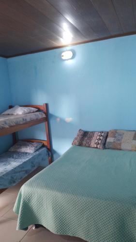 阿拉卡茹CASA DE TEMPORADA RECANTO FELIz 2的一间卧室设有两张双层床和蓝色的墙壁