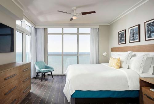 默特尔比奇Hilton Grand Vacations Club Ocean Enclave Myrtle Beach的一间卧室设有一张大床和一个大窗户