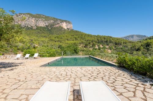 略塞塔艾格特斯莫费力莫斯酒店的一个带两把椅子的游泳池和一个山