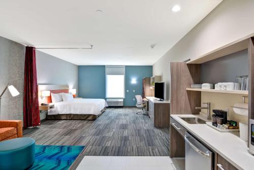 米德韦斯特城Home2 Suites by Hilton OKC Midwest City Tinker AFB的酒店客房带一张床和一个厨房