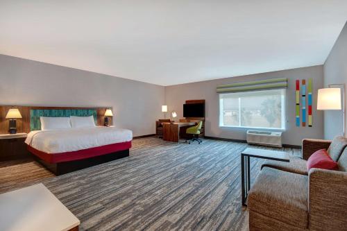 库卡蒙格牧场Hampton Inn & Suites By Hilton Rancho Cucamonga的大型酒店客房,配有一张床和一张书桌
