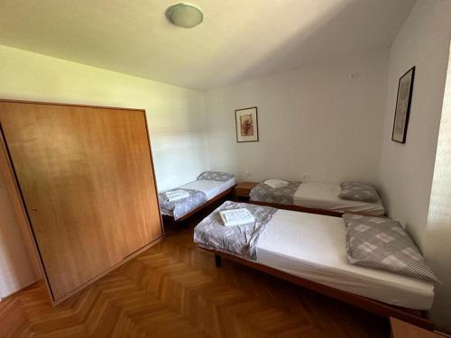 MaterijaHostel on the road trip的铺有木地板的客房内的两张床