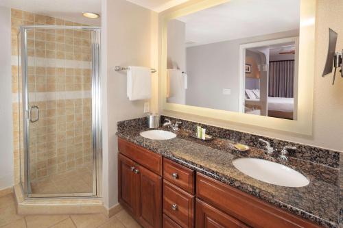 奥兰多Hilton Grand Vacations Club Tuscany Village Orlando的一间带两个盥洗盆和淋浴的浴室
