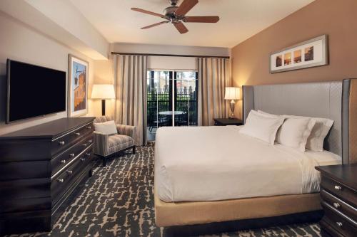 奥兰多Hilton Grand Vacations Club Tuscany Village Orlando的一间卧室配有一张床和一台平面电视