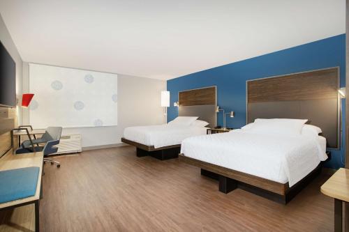 AudubonTru By Hilton Audubon Valley Forge的酒店客房设有两张床和蓝色的墙壁。