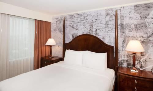 普利茅斯会议DoubleTree Suites by Hilton Hotel Philadelphia West的酒店客房设有一张床,墙上挂有地图