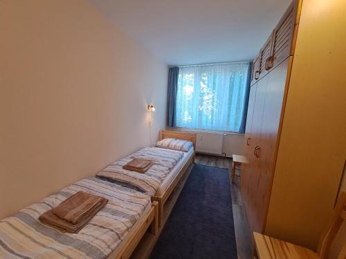科马罗姆Kaptár lakás的小型客房 - 带2张床和窗户