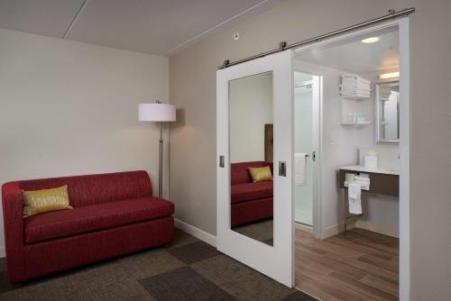 斯科茨汉普顿酒店凤凰-斯科茨代尔希亚大道的客厅配有红色的沙发和镜子