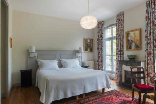 贝尔热拉克B&B Le Clos d'Argenson的卧室配有白色的床和椅子