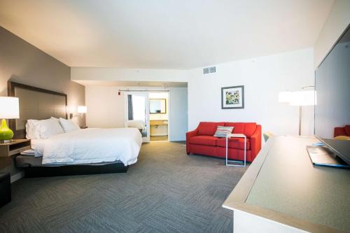 坦培亚利桑那州坦培/凤凰城机场汉普顿酒店的酒店客房,配有一张床和一张红色椅子