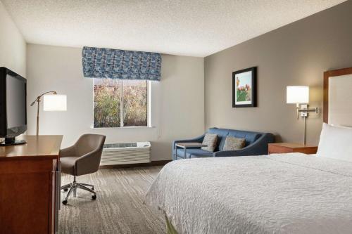 凤凰城Hampton Inn Phoenix Midtown Downtown Area的酒店客房配有一张床、一张书桌和一张沙发。
