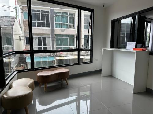 曼谷D Night Suite Hotel的客房设有2张凳子和大窗户。