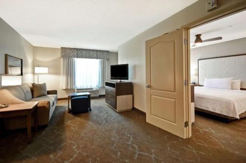 多佛多佛希尔顿惠庭套房酒店的酒店客房配有床、沙发和电视。