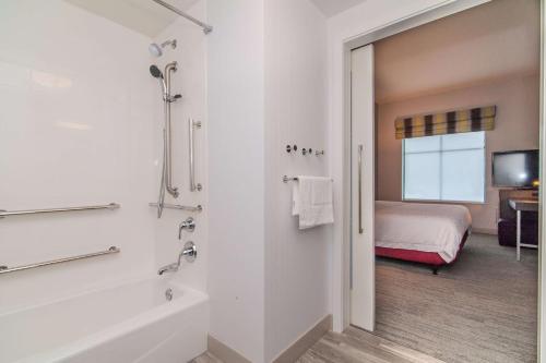诺维奇诺威奇汉普顿酒店的带浴缸的浴室和1间带1张床的卧室