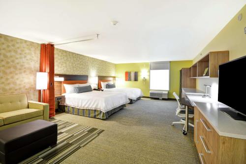 拉皮德城Home2 Suites By Hilton Rapid City的配有一张床和一张书桌的酒店客房