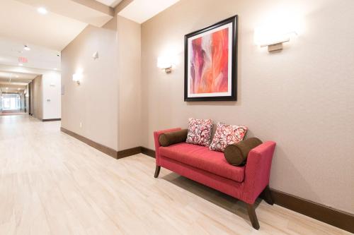 沃尔特伯勒Hampton Inn & Suites Walterboro的一间设有红色沙发和绘画的等候室
