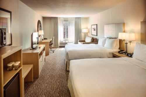 本德本德希尔顿逸林酒店的酒店客房设有两张床和电视。