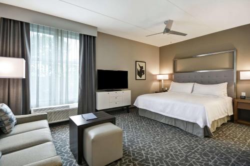 卡瑞Homewood Suites by Hilton Raleigh Cary I-40的酒店客房,配有床和电视