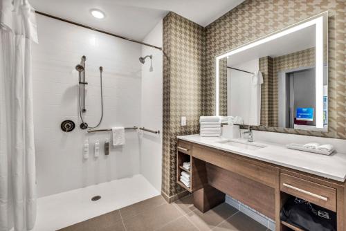 罗利Home2 Suites By Hilton Raleigh State Arena的带浴缸、水槽和镜子的浴室