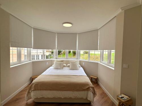 圣维森特-德拉巴尔克拉El Faro de la Barquera的一间卧室配有一张带窗户的大床