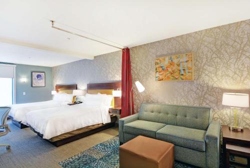 达拉姆Home2 Suites By Hilton Raleigh Durham Airport RTP的酒店客房,配有床和沙发