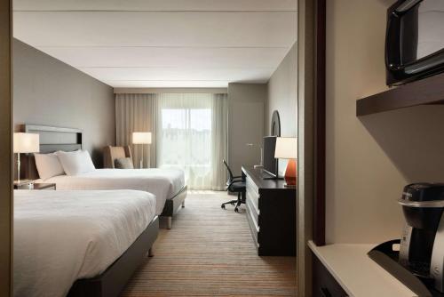 罗切斯特Hilton Garden Inn Rochester - University & Medical Center的酒店客房设有两张床和电视。