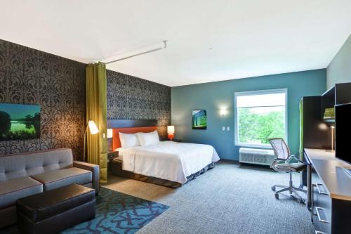 罗切斯特Home2 Suites by Hilton Rochester Mayo Clinic Area的酒店客房,配有床和沙发