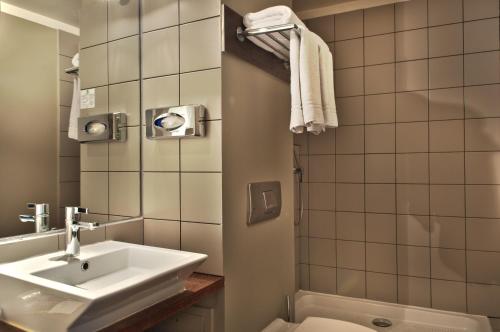 巴黎塞夫尔酒店的浴室配有盥洗盆、卫生间和浴缸。