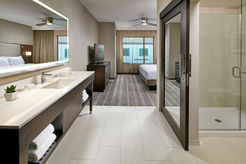 圣地亚哥圣地亚哥市中心/碧沙希尔顿惠庭套房酒店的一间带两个盥洗盆和淋浴的酒店浴室