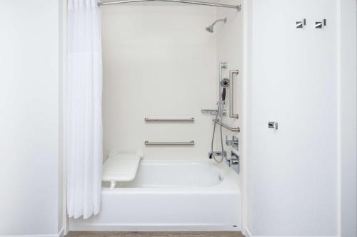 圣地亚哥Hampton Inn & Suites San Diego Airport Liberty Station的白色的浴室设有浴缸和淋浴。