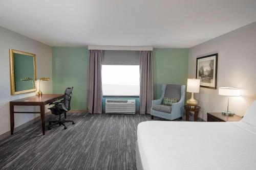 南本德本德南希尔顿花园酒店的配有一张床、一张书桌和一扇窗户的酒店客房