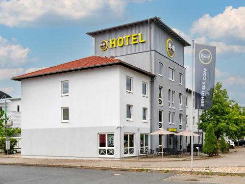 汉诺威B&B Hotel Hannover-Lahe的白色的建筑,上面有酒店标志