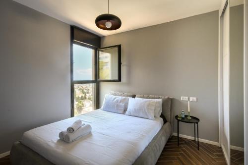 海法Stunning 2BR Apartment with Balcony and Ocean View in the Heart of Haifa by Sea N' Rent的卧室配有一张大白色床和窗户