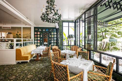 巴黎Hôtel Eldorado Paris的一间带桌椅和吊灯的餐厅