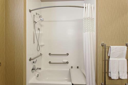 埃弗里特西雅图汉普顿酒店/埃弗里特市中心的带淋浴和白色浴缸的浴室
